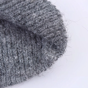 Primo piano di un maglione grigio lavorato a maglia con texture in mohair di qualità