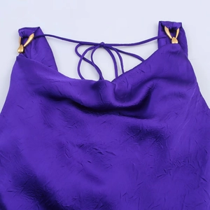 Abito longuette viola scuro in tessuto plissettato con anelli di metallo dorato sulle spalle