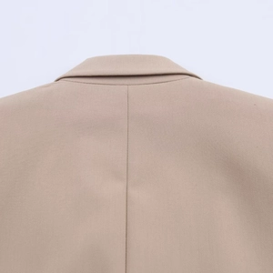 Detailed rear view of beige blazer featuring precise back seam and structured lapel stitch