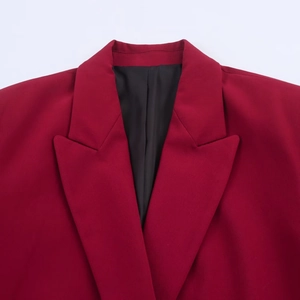 Detailed close-up of peak lapels and premium burgundy fabric on a tailored blazer