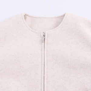 Detail of soft cream bomber jacket fabric with smooth metal zipper and round neckline