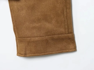 Detailed macro view of the double-stitched hem on high-quality brown faux suede jacket