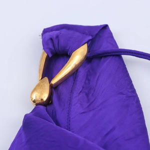 Dettaglio macro dell'abito midi in seta viola con hardware dorato in metallo