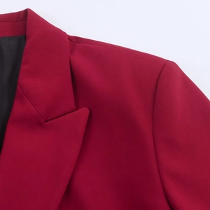 Detail of burgundy suit blazer featuring peak lapels and premium smooth fabric texture
