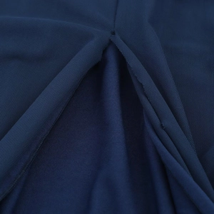 Detail of navy blue mesh fabric and silky lining with precise stitching on a long dress