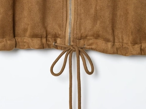 Detail of velvet jacket hem featuring metal zipper and adjustable drawstring closure