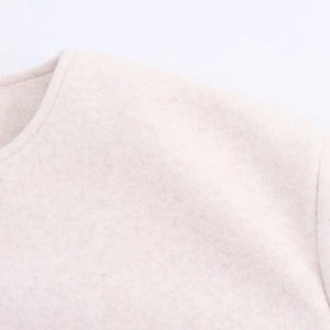 Detail of round neckline and thick wool fabric texture on this light beige bomber jacket