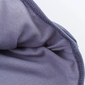 Makroaufnahme der violetten Strickstoffstruktur und dichten Overlocknaht am Kleidungsrand