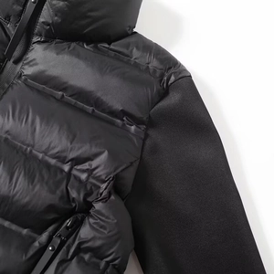 Détail d'une doudoune noire mêlant nylon brillant et textures mates aux épaules