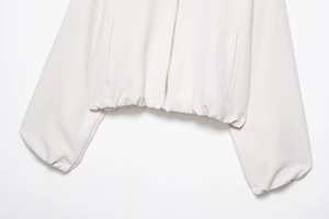 Vue détaillée de la veste beige clair avec zip métallique et ourlet élastique ajusté