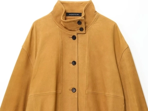 Detail view of the standing collar and buttons on a mustard yellow leather aviator jacket