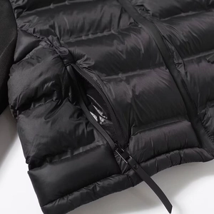 Détail d'une doudoune noire avec tirette de fermeture éclair texturée et tissu lisse