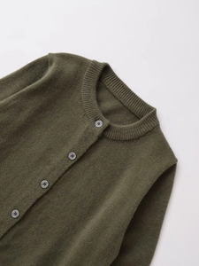 Detail of dark green knit cardigan neckline with marble pattern buttons and ribbed texture
