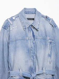 Détail de veste en jean bleu clair avec ceinture à la taille et col effet vieilli