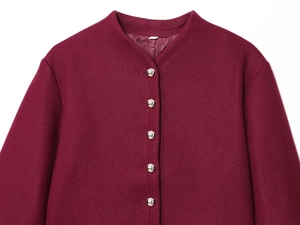 Detailed macro view of silver ball buttons on a burgundy wool coat with smooth satin lining