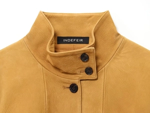 Close-up of mustard yellow leather aviator jacket collar with brand label and stitching
