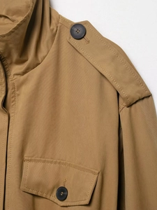 Detail of khaki jacket showing military-style epaulettes and matte black buttons