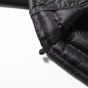 Gros plan détaillé de l'ourlet à cordon réglable sur une veste d'hiver noire matelassée