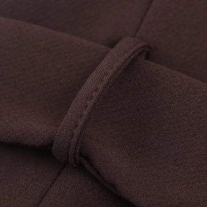 Détail du tissu marron foncé montrant des coutures de précision sur le passant de ceinture