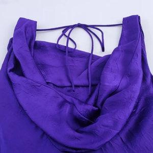 Dettaglio dell'abito midi in raso viola con scollo a cappuccio e trama a pieghe