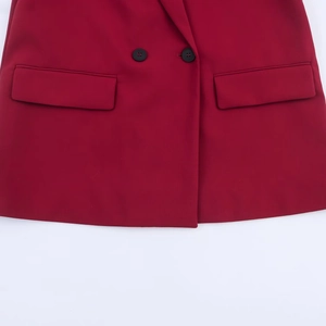 Detailed view of double-breasted closure and flap pockets on dark red blazer jacket