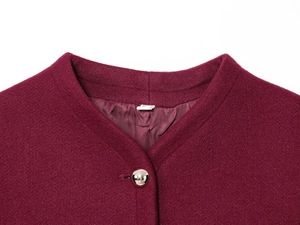 Close-up of wine red wool coat featuring a round neck and silver spherical metal button