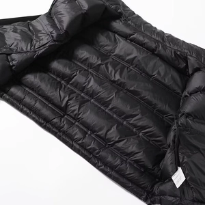 Détail du tissu matelassé noir brillant montrant le rembourrage et l'étiquette de lavage