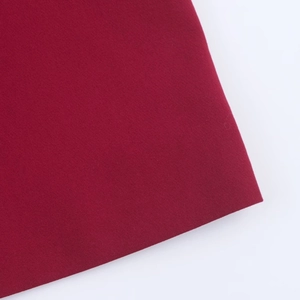 Detailed macro view of high-quality burgundy wine fabric texture for tailored blazers