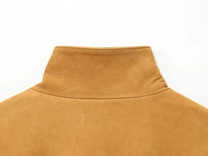 Detailed macro view of mustard yellow faux leather collar with precise stitching work