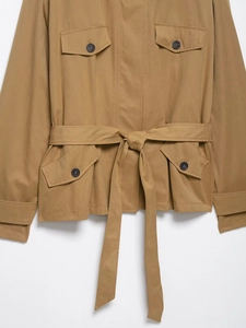 Close-up of khaki trench coat featuring four flap pockets and adjustable belted waist