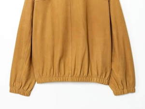 Detailed view of back seam and elastic hem on a ginger faux leather bomber jacket