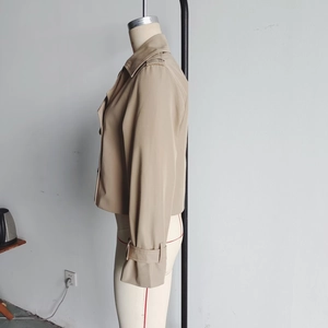 Side view of khaki short trench jacket showing adjustable cuff straps and classic lapel