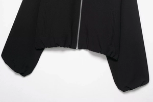 Vue détaillée d'une veste noire à fermeture éclair avec ourlet élastique pour femmes