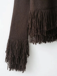 Detail of dark brown knit cardigan featuring long fringe tassels and textured yarn