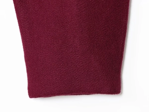 Detailed close-up of deep burgundy fleece fabric with soft milled texture on fashion jacket