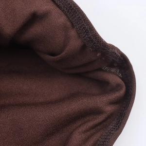 Detailaufnahme von dunkelbraunem Strickstoff mit feiner Textur und verstärkter Kantennaht