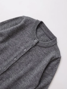 Detail of grey wool-blend knit cardigan featuring a round neck and tonal resin buttons