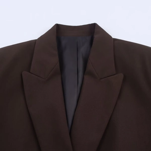 Detail of dark brown suit blazer featuring a notched lapel and high-quality stitching