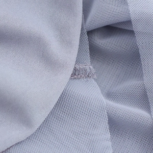 Macro shot of light blue breathable mesh fabric texture and reinforced stitching detail