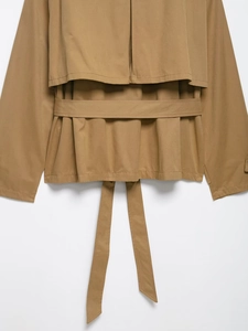 Detail view of khaki trench coat back flap and matching waist belt in structured fabric