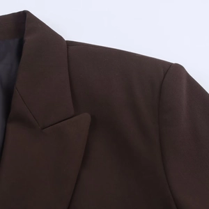 Close-up of the dark brown oversized blazer lapel and shoulder seam detail