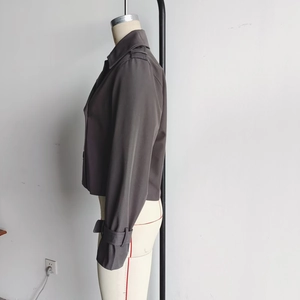 Side view of dark gray cropped trench coat with epaulettes and adjustable sleeve straps