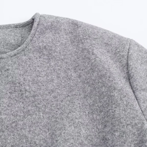 Detailed close-up showing the soft grey textured fabric and crew neck seam of the bomber jacket
