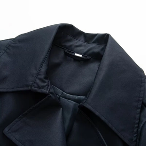 Detailed close-up of the lapel collar and fine stitching on a navy blue trench coat