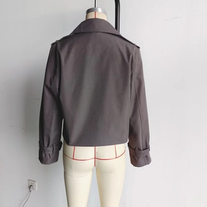 Rear view of a dark taupe cropped trench jacket featuring shoulder epaulets and buckled cuffs