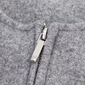 Macro detail of silver metal zipper on soft grey fleece pilot jacket fabric texture