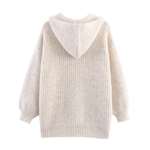Detail of coarse knit texture and ribbed hem on a beige hooded oversized sweater