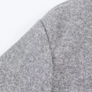 Close-up of shoulder seam and soft grey wool-blend fabric on women's bomber jacket