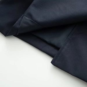 Detail view of navy blue trench coat fabric showing precise stitching and satin lining