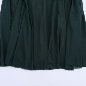 Detail of dark green pleated mesh fabric layers and hem of long sleeveless dress